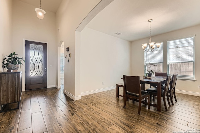 2215 Zachry, New Braunfels, TX 78132 - dining area with arched walkways, dark wood-type flooring, a chandelier, and baseboards