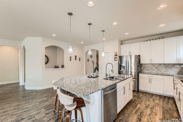 2215 Zachry, New Braunfels, TX 78132 - kitchen featuring a sink, stainless steel appliances, arched walkways, recessed lighting, and light stone counters