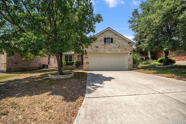 12518 Cascade Hls, San Antonio, TX 78253 - obstructed view of property featuring driveway, an attached garage, central air condition unit, stone siding, and brick siding