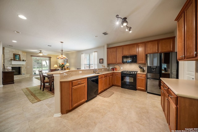 12518 Cascade Hls, San Antonio, TX 78253 - kitchen featuring black appliances, brown cabinets, a sink, a peninsula, and decorative backsplash