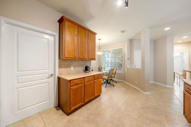12518 Cascade Hls, San Antonio, TX 78253 - kitchen featuring light countertops, brown cabinetry, decorative backsplash, baseboards, and light tile patterned floors