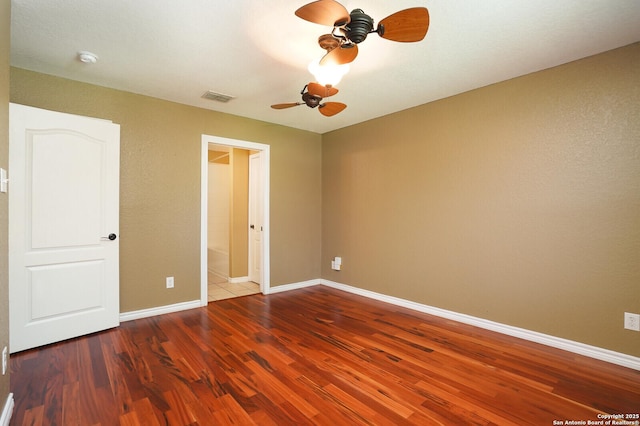 631 Sanderling, San Antonio, TX 78245 - unfurnished bedroom featuring wood finished floors, baseboards, a ceiling fan, and ensuite bathroom