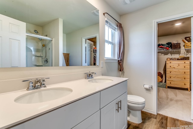 7010 Whipsaw Pt, San Antonio, TX 78253 - bathroom with a stall shower, wood finished floors, a spacious closet, toilet, and double vanity