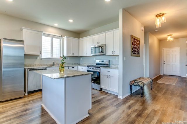 7010 Whipsaw Pt, San Antonio, TX 78253 - kitchen with stainless steel appliances, white cabinets, wood finished floors, recessed lighting, and a center island