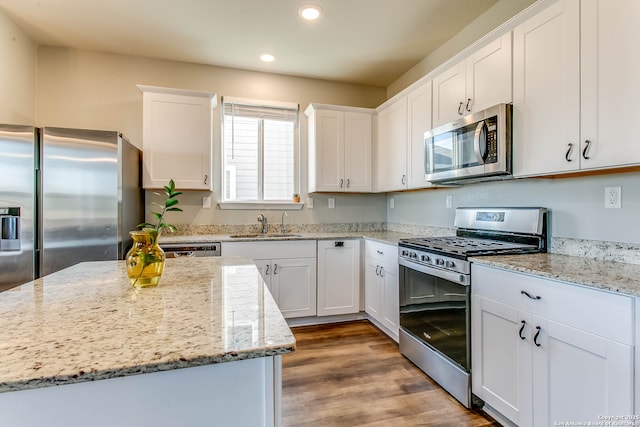 7010 Whipsaw Pt, San Antonio, TX 78253 - kitchen with appliances with stainless steel finishes, recessed lighting, white cabinets, light stone counters, and a center island