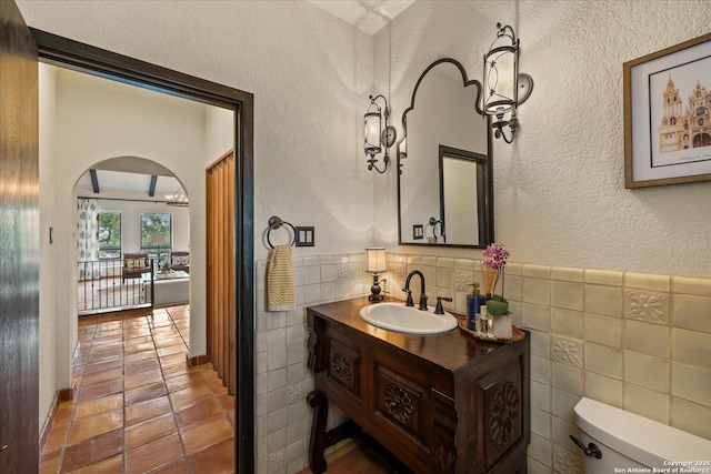 8122 Triple Crown, Fair Oaks Ranch, TX 78015 - bathroom with tile walls, toilet, tile patterned flooring, vanity, and a textured wall
