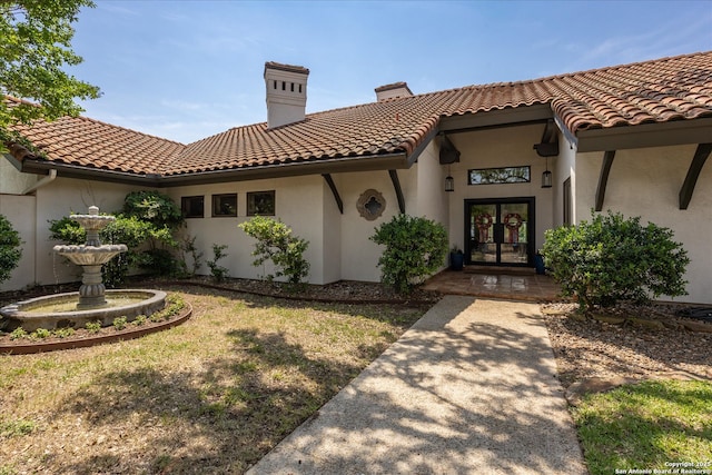 8122 Triple Crown, Fair Oaks Ranch, TX 78015 - view of front of home featuring french doors, stucco siding, a tile roof, and a chimney