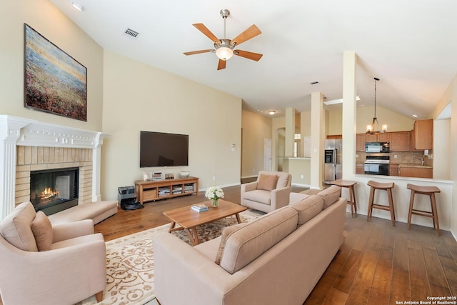 24931 Crescent Run, San Antonio, TX 78258 - living area featuring vaulted ceiling, wood finished floors, ceiling fan, a chandelier, and a brick fireplace