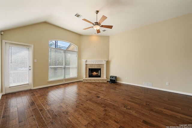24931 Crescent Run, San Antonio, TX 78258 - unfurnished living room featuring ceiling fan, dark wood-type flooring, a brick fireplace, vaulted ceiling, and baseboards