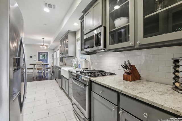 621 Center St, San Antonio, TX 78202 - kitchen with appliances with stainless steel finishes, gray cabinets, a sink, light stone counters, and recessed lighting