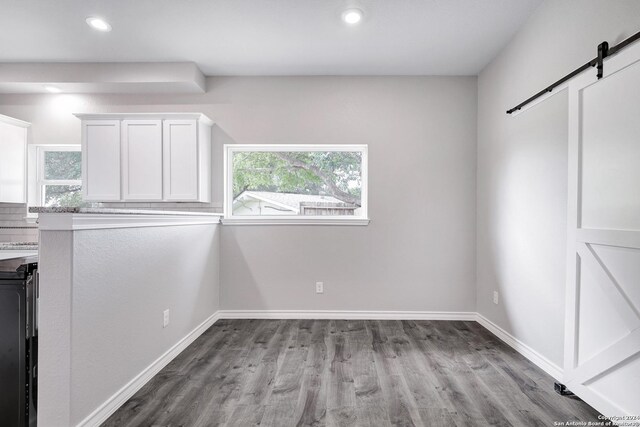 123 Riviera, Castle Hills, TX 78213 - unfurnished dining area featuring a barn door, wood finished floors, baseboards, and recessed lighting