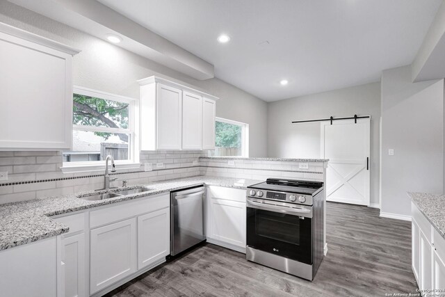 123 Riviera, Castle Hills, TX 78213 - kitchen with stainless steel appliances, a sink, decorative backsplash, white cabinets, and a barn door