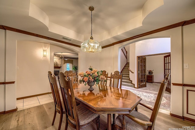13742 Corinth, Universal City, TX 78148 - dining space featuring arched walkways, ceiling fan, a raised ceiling, stairs, and light wood-type flooring