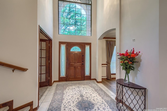 13742 Corinth, Universal City, TX 78148 - foyer featuring arched walkways, inlaid floor details, a towering ceiling, light tile patterned flooring, and baseboards