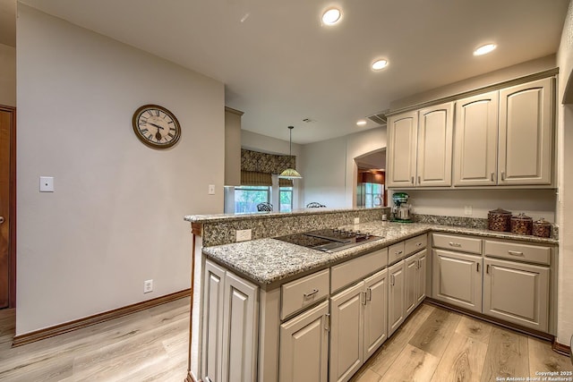 13742 Corinth, Universal City, TX 78148 - kitchen with black electric stovetop, light wood finished floors, a peninsula, light stone counters, and decorative light fixtures