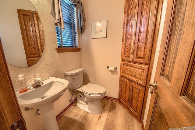 13742 Corinth, Universal City, TX 78148 - half bath featuring toilet, wood finished floors, a sink, and baseboards