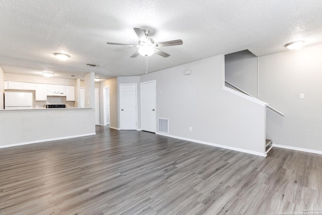546 Dukeway, Universal City, TX 78148 - unfurnished living room with a textured ceiling, ceiling fan, wood finished floors, stairs, and baseboards