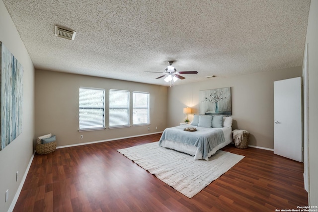 9838 Trendwood, San Antonio, TX 78250 - bedroom with dark wood-style floors, baseboards, ceiling fan, and a textured ceiling