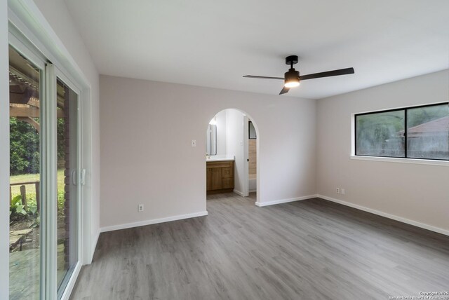 7927 Misty Park, San Antonio, TX 78250 - spare room featuring arched walkways, wood finished floors, ceiling fan, and baseboards