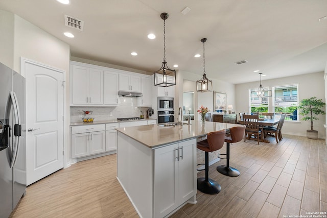 4610 Honeydew Rdg, San Antonio, TX 78253 - kitchen with stainless steel appliances, under cabinet range hood, light wood-style flooring, white cabinets, and recessed lighting