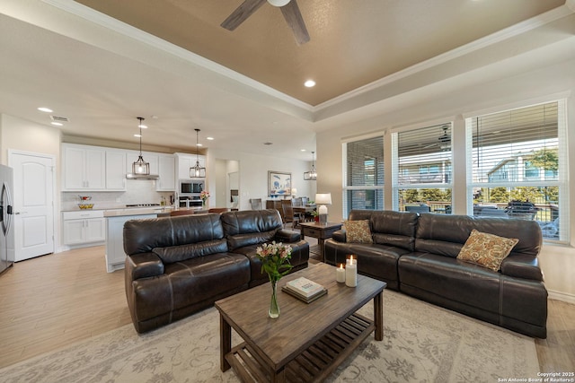 4610 Honeydew Rdg, San Antonio, TX 78253 - living area with light wood-style floors, healthy amount of natural light, crown molding, a ceiling fan, and a raised ceiling