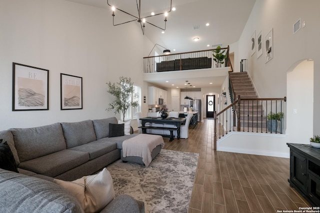 2130 Dalhart, San Antonio, TX 78253 - living room featuring arched walkways, a high ceiling, stairway, a chandelier, and dark wood-style floors
