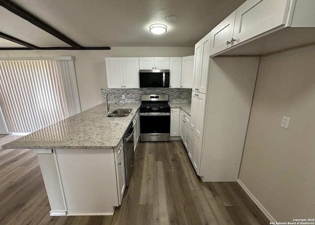 459 Maddux, San Antonio, TX 78227 - kitchen with stainless steel appliances, a sink, a peninsula, white cabinets, and backsplash