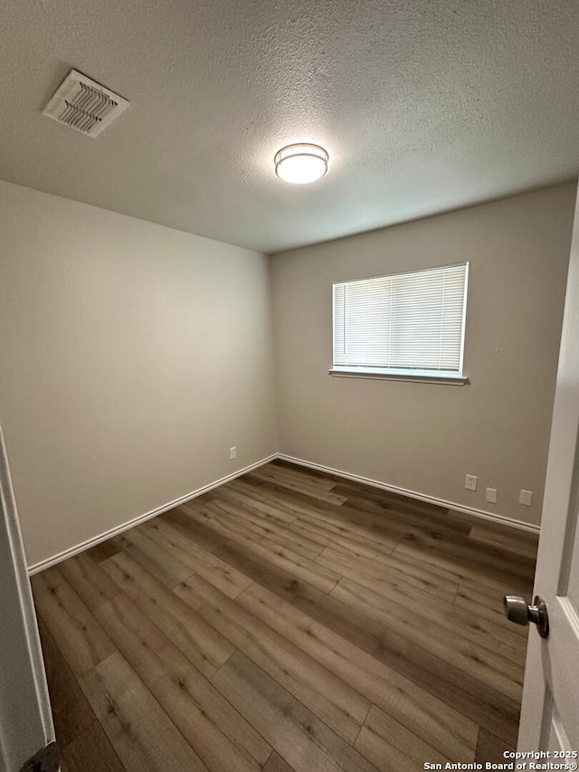459 Maddux, San Antonio, TX 78227 - empty room with dark wood-style floors, a textured ceiling, and baseboards