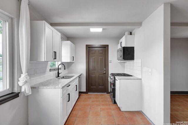 4207 Tallulah, San Antonio, TX 78218 - kitchen with a sink, appliances with stainless steel finishes, tasteful backsplash, light stone counters, and white cabinetry
