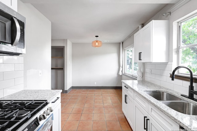 4207 Tallulah, San Antonio, TX 78218 - kitchen featuring appliances with stainless steel finishes, a sink, light tile patterned flooring, and backsplash