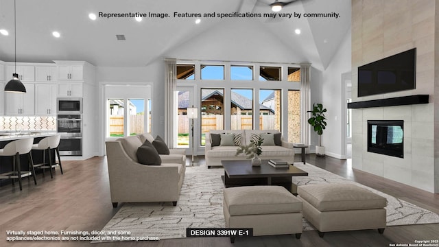 301 Barton Crk, Boerne, TX 78006 - living area featuring high vaulted ceiling, light wood finished floors, a tiled fireplace, recessed lighting, and baseboards