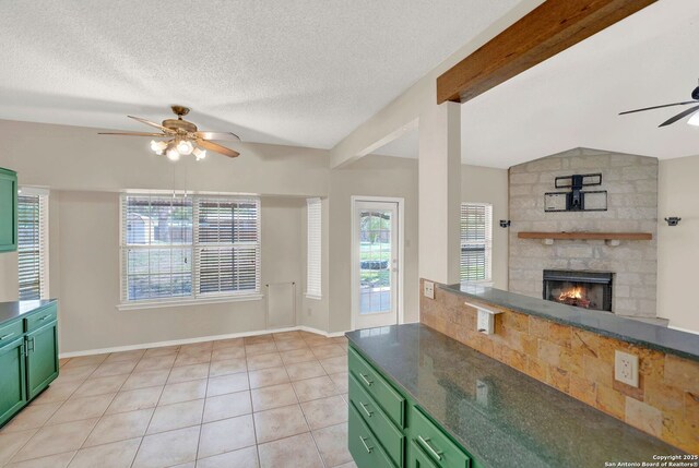 1314 Acorn, Hondo, TX 78861 - kitchen with green cabinetry, a ceiling fan, a fireplace, light tile patterned floors, and a textured ceiling