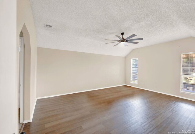 1314 Acorn, Hondo, TX 78861 - empty room featuring a ceiling fan, plenty of natural light, lofted ceiling, a textured ceiling, and dark wood-style flooring