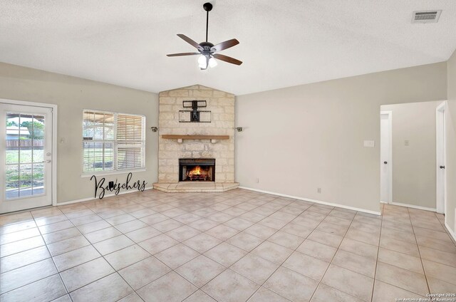1314 Acorn, Hondo, TX 78861 - unfurnished living room with ceiling fan, vaulted ceiling, light tile patterned floors, a stone fireplace, and baseboards