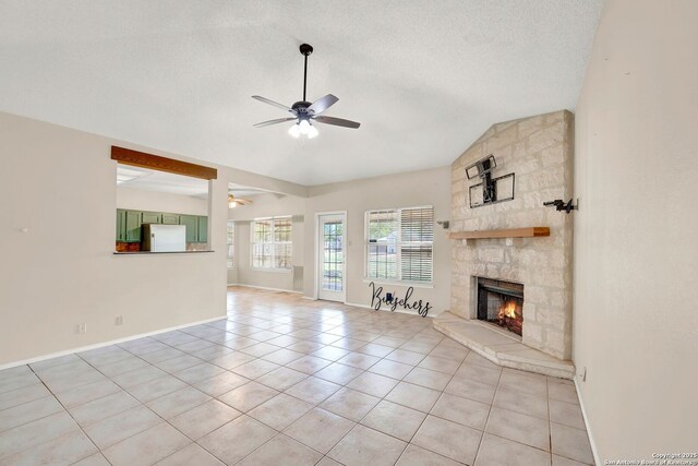 1314 Acorn, Hondo, TX 78861 - unfurnished living room with a ceiling fan, vaulted ceiling, light tile patterned flooring, a fireplace, and baseboards