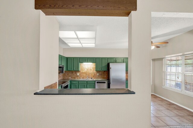 1314 Acorn, Hondo, TX 78861 - kitchen with green cabinets, appliances with stainless steel finishes, backsplash, light tile patterned flooring, and ceiling fan