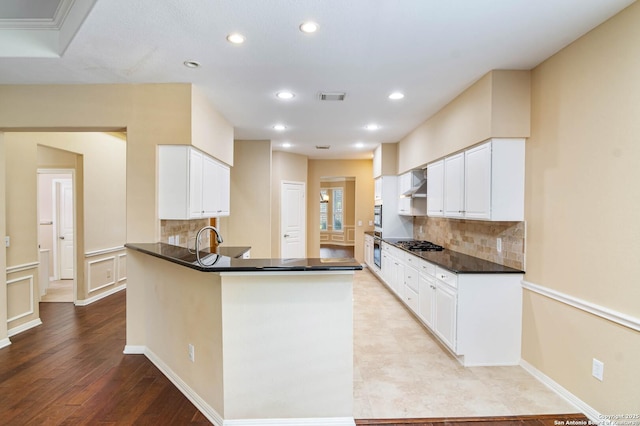 2426 Enfield Grove, San Antonio, TX 78231 - kitchen with wall chimney exhaust hood, dark countertops, backsplash, recessed lighting, and light wood-style flooring