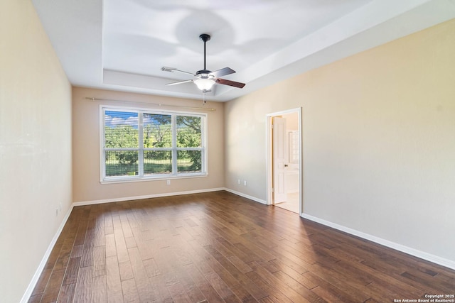 2426 Enfield Grove, San Antonio, TX 78231 - unfurnished room featuring dark wood-style floors, ceiling fan, baseboards, and a tray ceiling