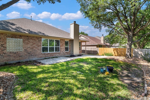 2426 Enfield Grove, San Antonio, TX 78231 - back of house featuring brick siding, roof with shingles, a patio area, and a chimney