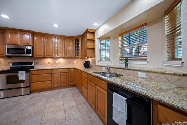 103 River Mdw, Castroville, TX 78009 - kitchen featuring stainless steel appliances, decorative backsplash, a sink, light stone counters, and recessed lighting