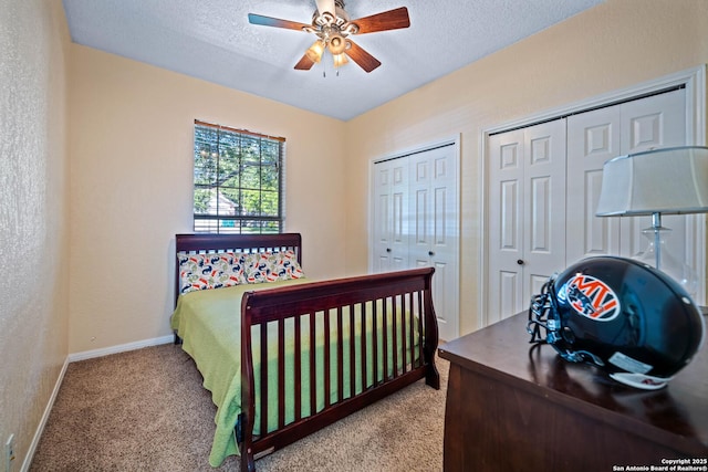 103 River Mdw, Castroville, TX 78009 - bedroom featuring carpet, two closets, a textured ceiling, baseboards, and ceiling fan