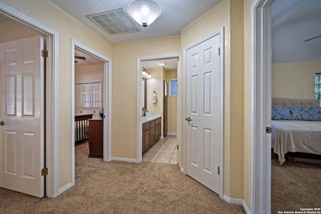 103 River Mdw, Castroville, TX 78009 - hallway with light carpet, baseboards, and a sink