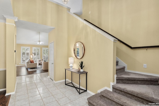 18852 Agin Ct, San Antonio, TX 78258 - stairway with baseboards, a ceiling fan, tile patterned floors, and a towering ceiling