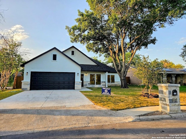 modern farmhouse style home with stone siding, a front lawn, concrete driveway, an attached garage, and stucco siding