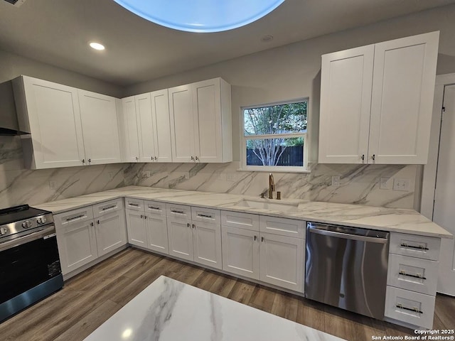 kitchen featuring stainless steel appliances, a sink, white cabinetry, and recessed lighting
