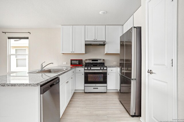 11947 Sand Wedge, San Antonio, TX 78221 - kitchen featuring appliances with stainless steel finishes, under cabinet range hood, a sink, a peninsula, and white cabinetry