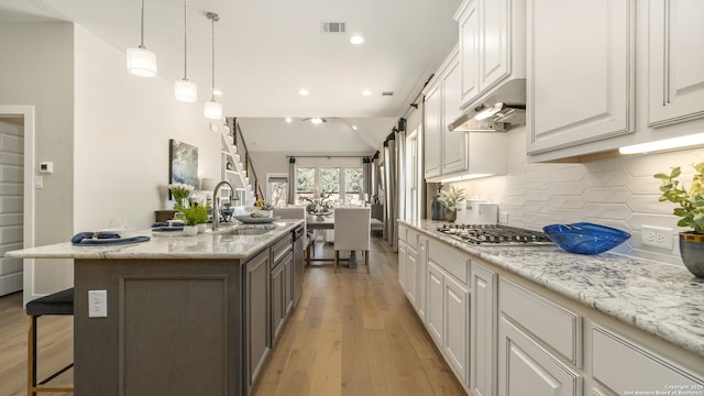 4207 Colina Crst, San Antonio, TX 78261 - kitchen with under cabinet range hood, a sink, white cabinetry, decorative backsplash, and recessed lighting