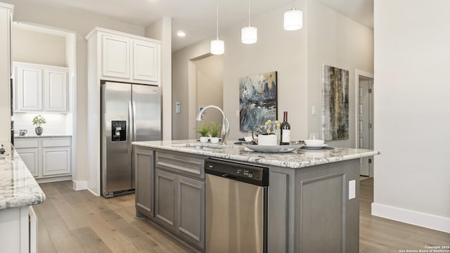 4207 Colina Crst, San Antonio, TX 78261 - kitchen featuring appliances with stainless steel finishes, a sink, light wood-type flooring, white cabinetry, and recessed lighting