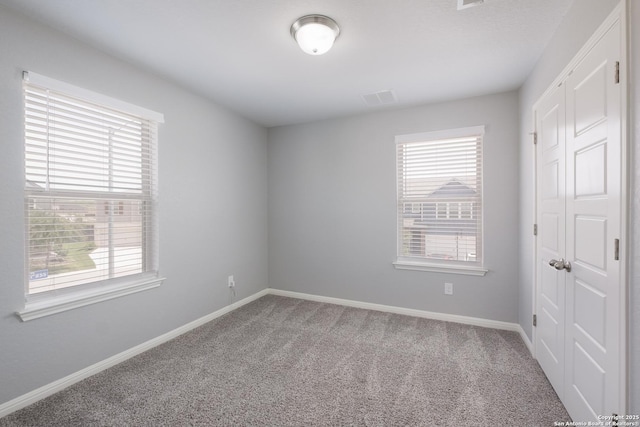 11510 Bakersfield Pass, San Antonio, TX 78245 - unfurnished bedroom with multiple windows, carpet flooring, and a closet