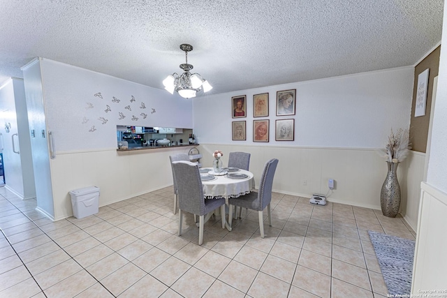 5003 Rustic Rdg, San Antonio, TX 78228 - dining space with a chandelier, wainscoting, a textured ceiling, light tile patterned flooring, and crown molding